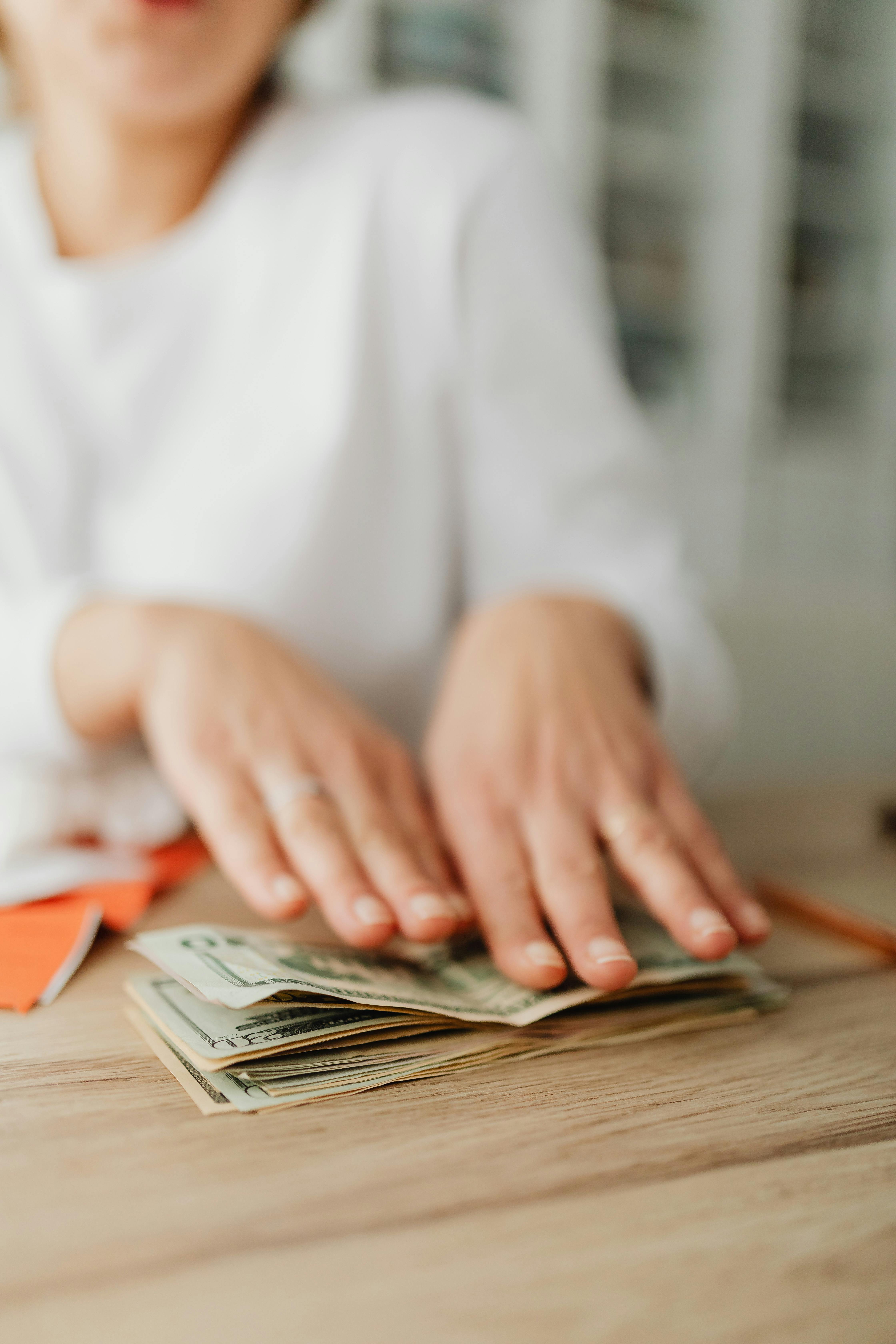 A buyer counting cash beside receipts at a desk, illustrating take-home-pay and reserve planning.