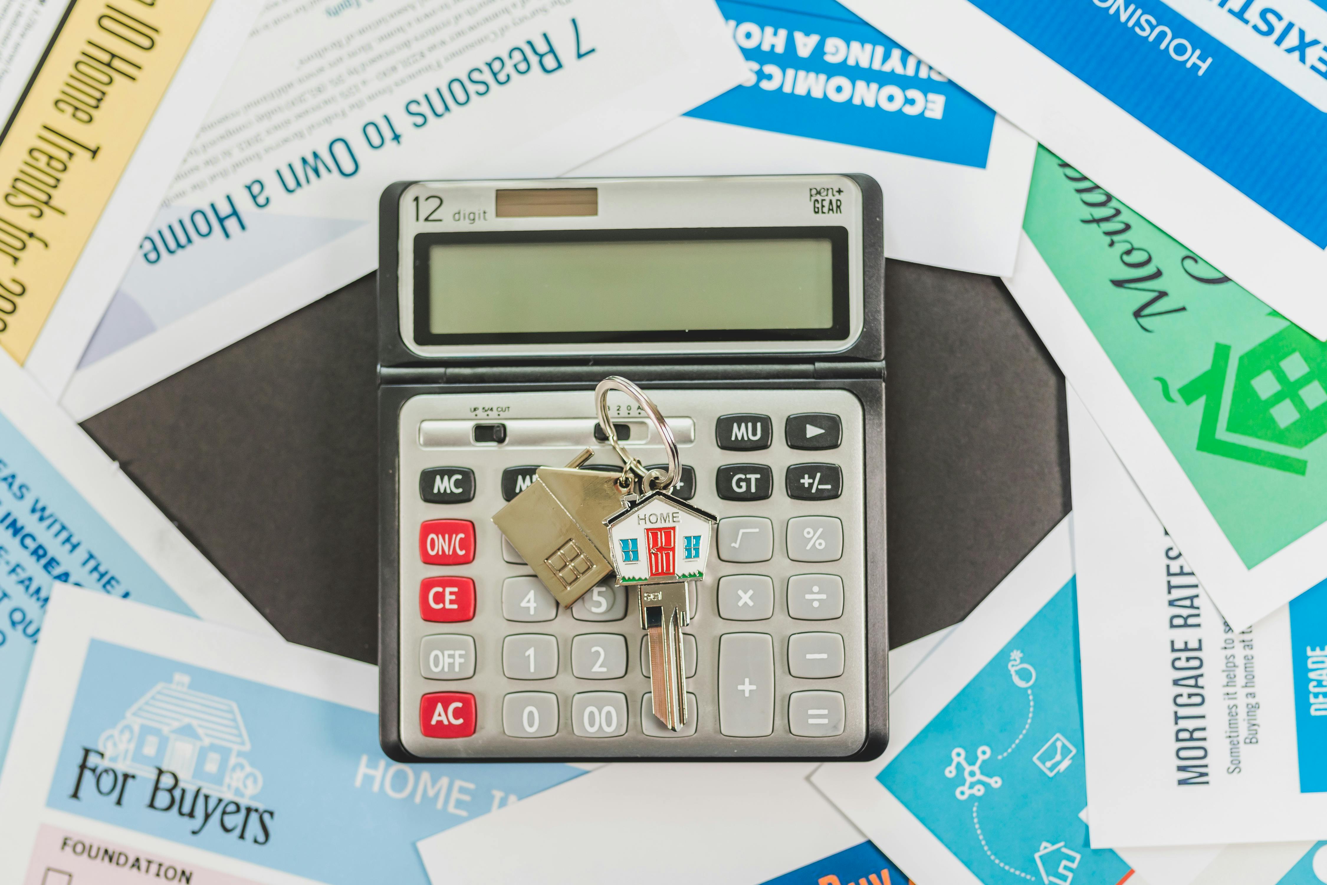 A calculator, receipts, and a pen on a desk, representing a pre-tour housing budget worksheet.