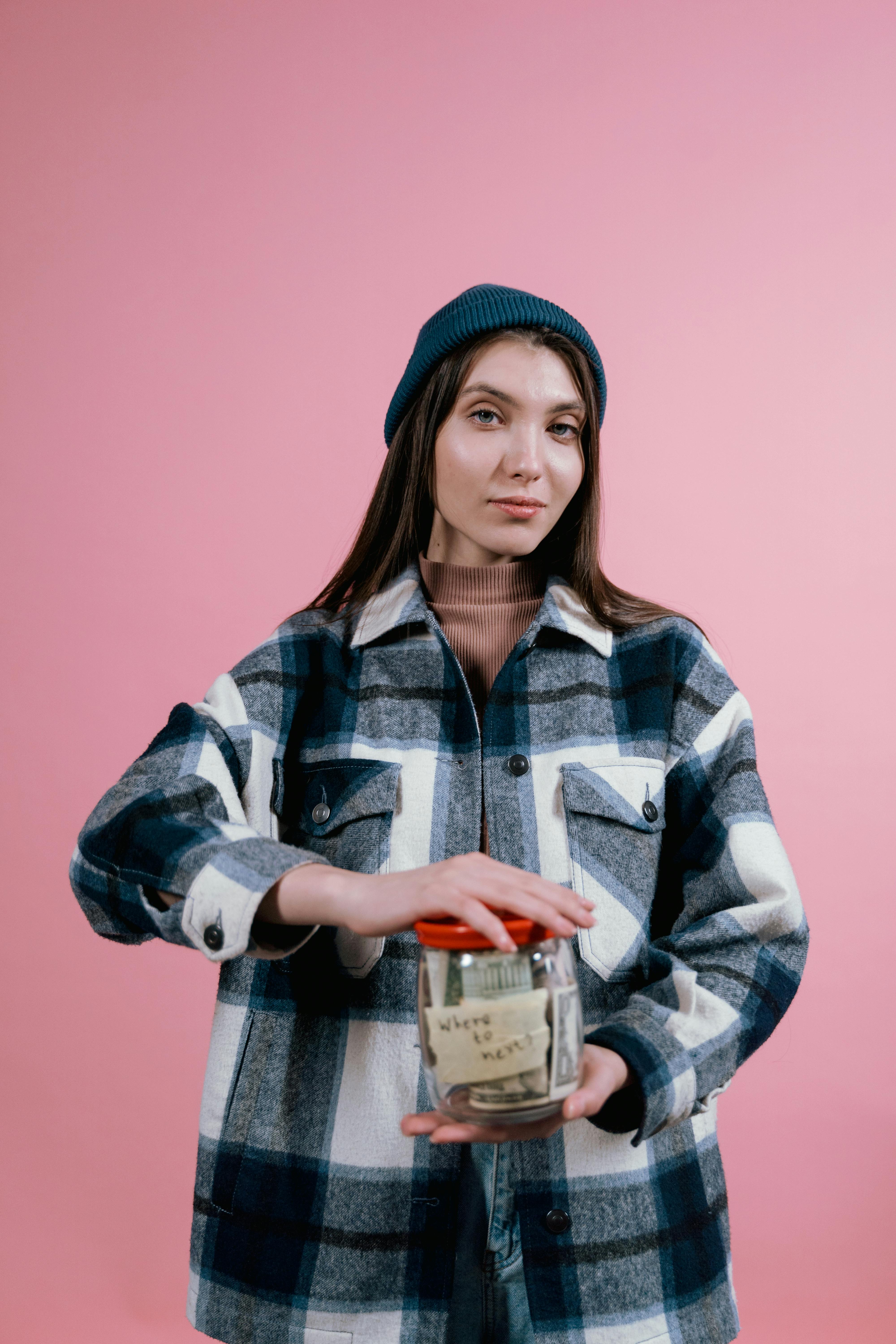 A woman holding a jar labeled savings, representing reserve cash that should remain visible in a housing budget.